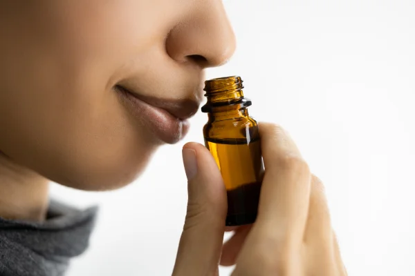 estimular el olfato con aceites esenciales, mujer oliendo aceite esencial
