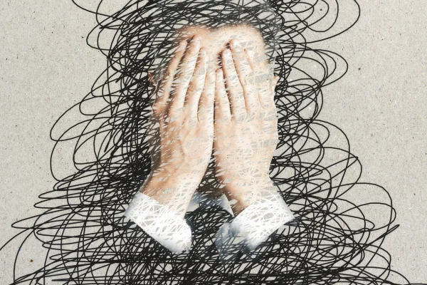 causas del estres con dos manos sobre la cara de un hombre en una imagen distorsionada