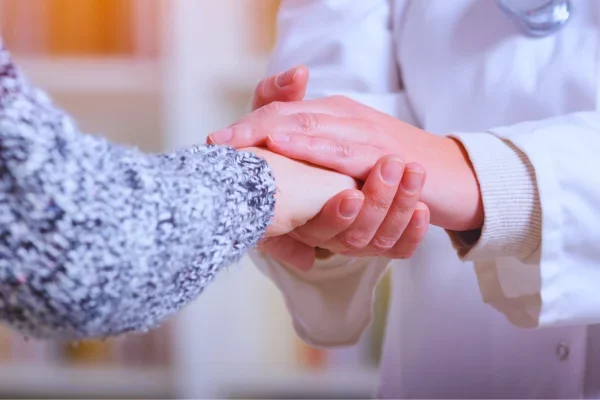 Medico sostiene la mano de paciente en medicina integrativa